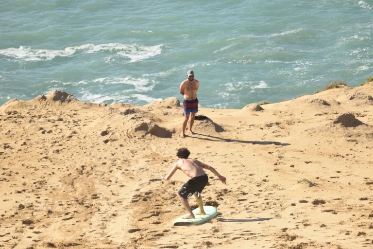Sandboarder glides down the dunes