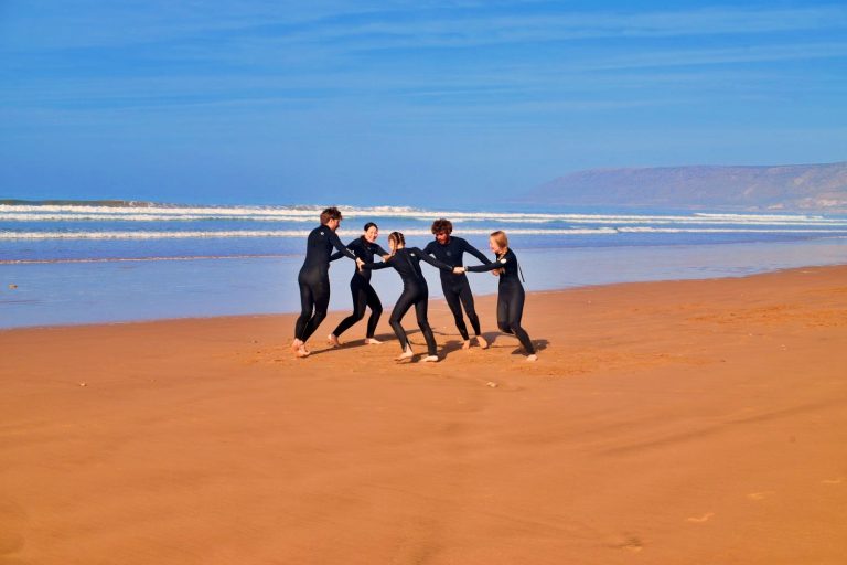 A family on the beach of Aghroud in Morocco warming up for the next surf course