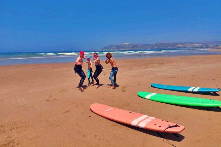 Family positioned together with the surf instructor on the beach in Agadir