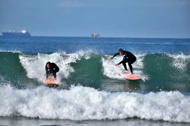 Two men practicing take-off in the green waves
