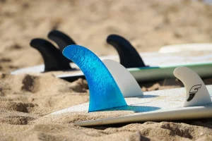 Three surfboards lie on the beach