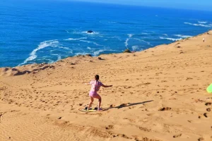 A young girl glides down the dunes in the Little Sahra with a snowboard
