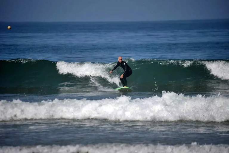 Surf student practising turning in the green waves during a private lesson