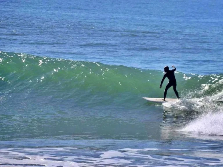 Surfer rides a perfect green wave