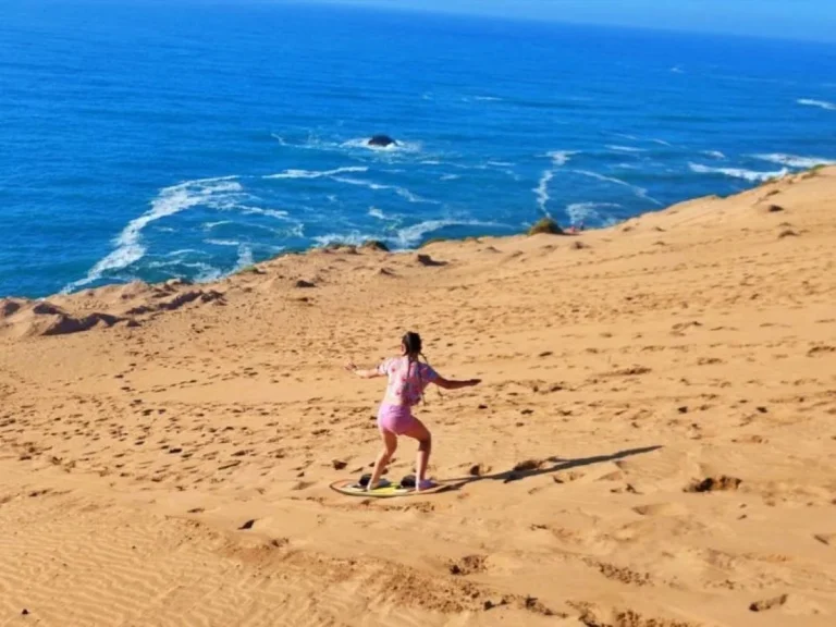 Sandboarding in the Little Sahara with a direct view of the Atlantic Ocean