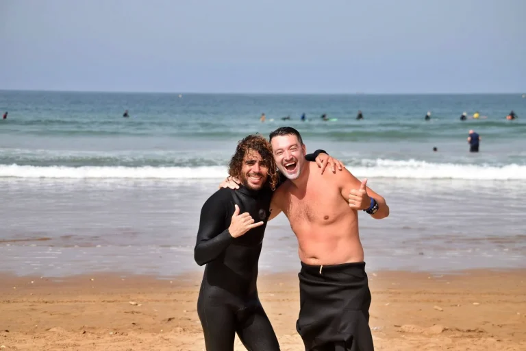Course participants and surf instructors pose on the beach in Agadir after a successful private course