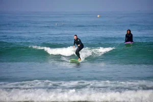 Surf student in private surf lessons successfully rides his first green waves
