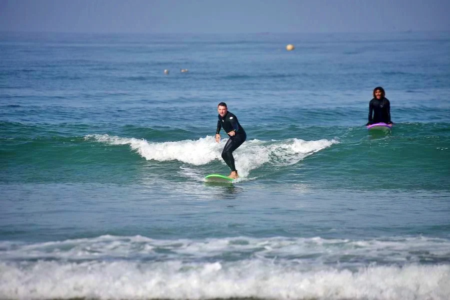 Surf student in private surf lessons successfully rides his first green waves
